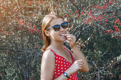 Young woman near bush with red hawthorn berries. smile, natural beauty