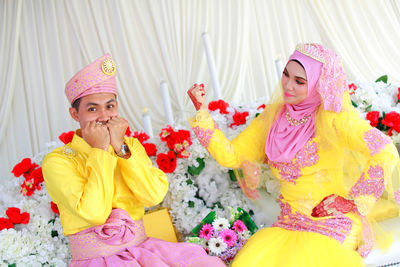 Bridal couple in traditional clothing posing during wedding celebration