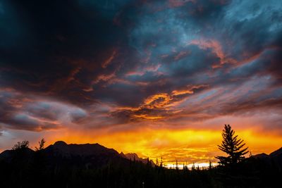 Scenic view of dramatic sky over silhouette landscape