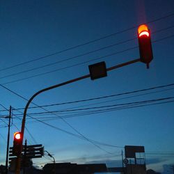 Low angle view of electricity pylon against blue sky