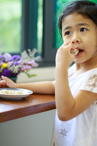 Cute girl eating food while looking away