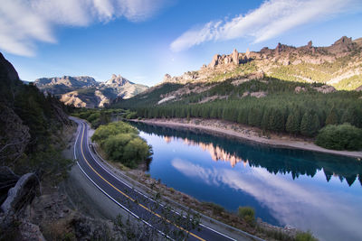 Scenic view of river by mountains against sky