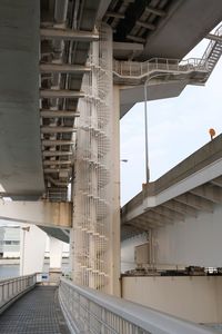 Bridge by buildings in city against sky