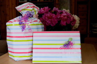 Close-up of purple flowers on table and packed gifts. 