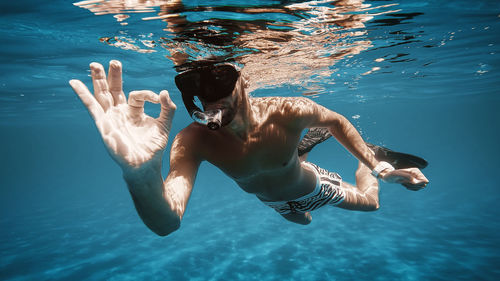 Boy snorkels with mask in the open sea