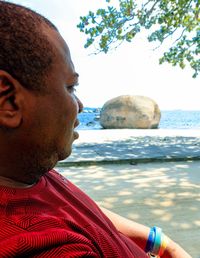 Close-up of man by sea against sky