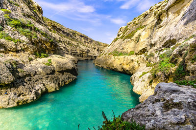 Scenic view of river amidst rocks against sky
