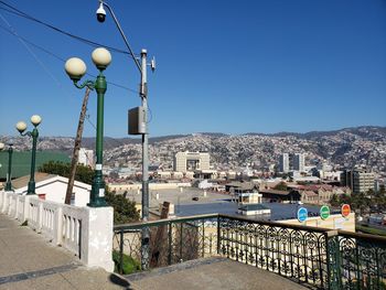 Street amidst buildings against clear blue sky