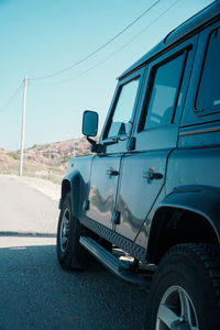 Side view of vehicles on road against the sky