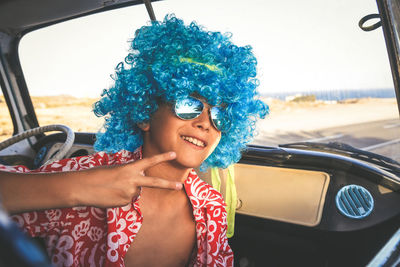 Close-up of boy in car against sky