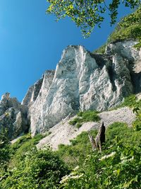 Low angle view of rocks against clear blue sky