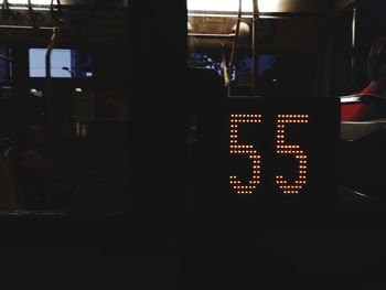 Illuminated text on glass window at night