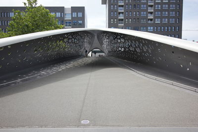 Man standing on bridge in city