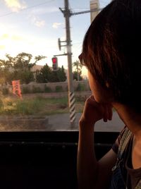 Woman looking through window while traveling in car