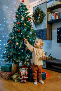 Children playing with christmas tree at home
