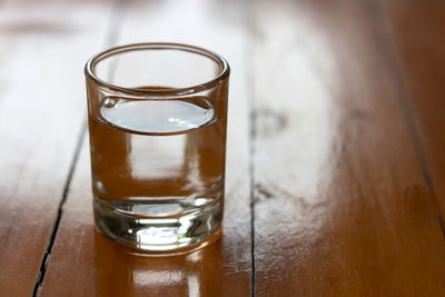 Close-up of water in drinking glass on wooden table