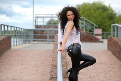 Portrait of smiling mature woman standing on footpath