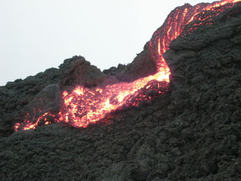 View of lit candle in the dark