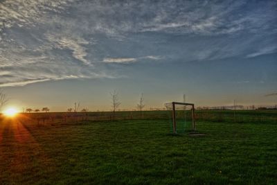 Scenic view of grassy field against cloudy sky