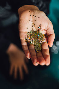 Hand holding gold glitter close up