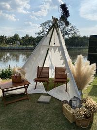 Chairs and table in park against sky