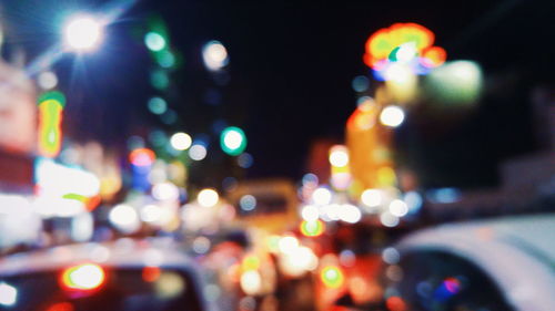 Defocused image of cars at illuminated street at night