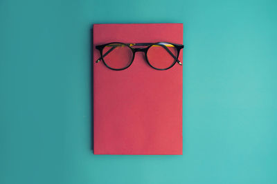 Directly above shot of eyeglasses on table against blue background