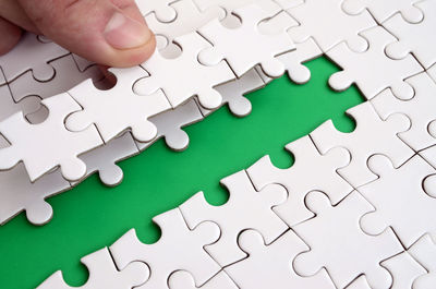Close-up of hand arranging jigsaw puzzle