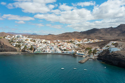 High angle view of townscape by sea against sky