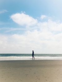 Woman on beach against sky