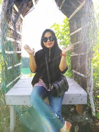 Portrait of young woman sitting on plant