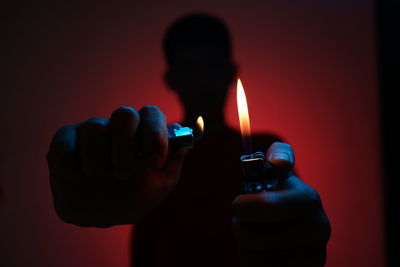 Close-up of hand holding lit candle