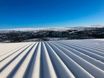 Scenic view of snow covered landscape against clear blue sky