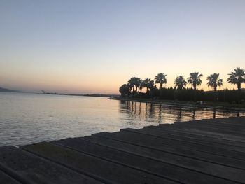 Scenic view of lake against clear sky during sunset