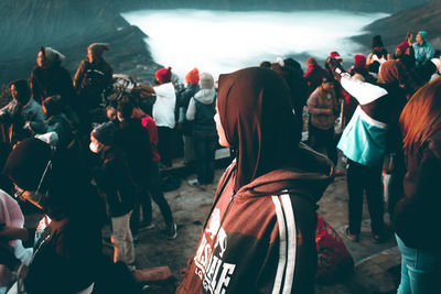 Rear view of people walking on shore