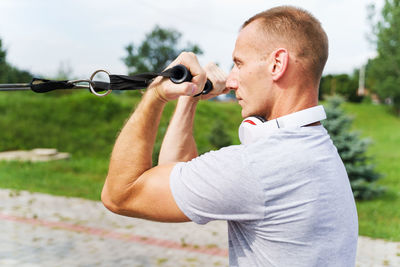 Side view of young man holding camera