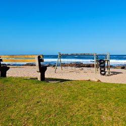 Scenic view of beach against clear blue sky