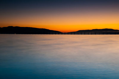 Scenic view of sea against clear sky at sunset