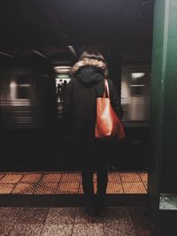 Woman standing on railroad station platform