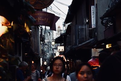 People on illuminated street in city