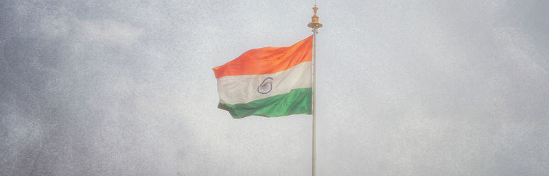 Low angle view of flag hanging against white wall