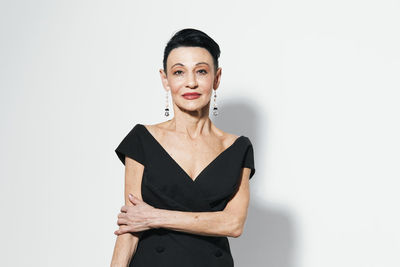 Portrait of young woman standing against white background