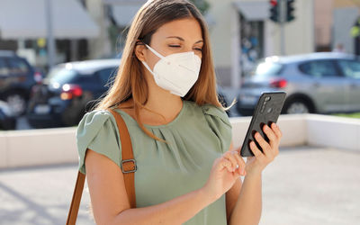 Portrait of young woman using mobile phone on street