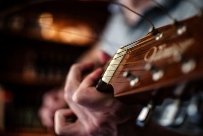 Midsection of man playing acoustic guitar