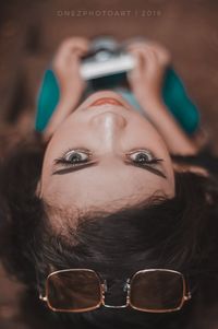 Close-up portrait of young woman using smart phone