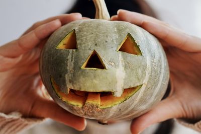 Midsection of person holding pumpkin