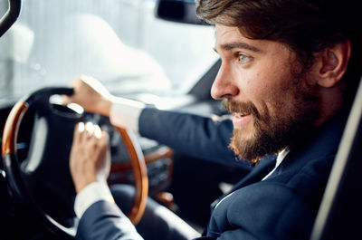 Close-up of young businessman sitting in car