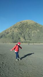 Full length of woman on sand against clear sky