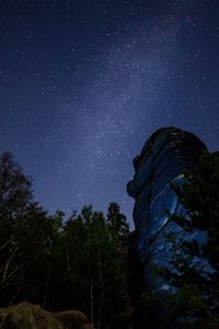 Low angle view of rock formation against sky at night