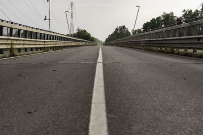 Surface level of road by bridge against sky